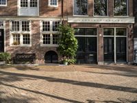 the girl is riding her bicycle in front of the building with the large windows of the old town house