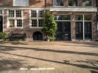 the girl is riding her bicycle in front of the building with the large windows of the old town house