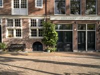 the girl is riding her bicycle in front of the building with the large windows of the old town house