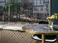 a window view of a restaurant with bikes parked outside it on a brick street in the city