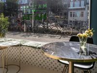 a window view of a restaurant with bikes parked outside it on a brick street in the city