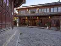 an old chinese looking building on the side of a street in front of a store