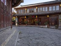 an old chinese looking building on the side of a street in front of a store