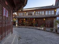 an old chinese looking building on the side of a street in front of a store