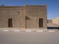a very wide brick and concrete wall with street lamps on top of it in the middle of the street