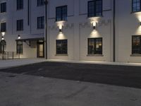 an apartment building with lights around it and a fire hydrant on the street near by