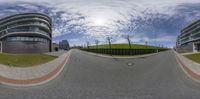 a fisheye lens shows a car turning on a street in front of apartment buildings