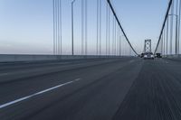 an approaching car on the bridge at dusk with blurry traffic in the background, with cars driving on road