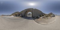 there is a view of an arch and cars on the road in a panorama point lens