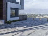 the exterior and landscape of a modern house in los angeles, california with stone and wood