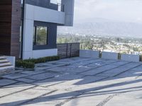 the exterior and landscape of a modern house in los angeles, california with stone and wood