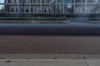 a red fire hydrant sitting in front of a building that looks like a glass block