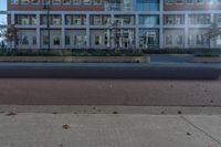 a red fire hydrant sitting in front of a building that looks like a glass block