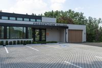 an architectural office building designed to look like an exhibition gallery, and is surrounded by a nice cobblestone area