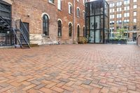 red brick floor with two building in the background from top of a roof and on the ground is a brick wall