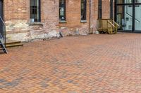 red brick floor with two building in the background from top of a roof and on the ground is a brick wall