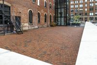 red brick floor with two building in the background from top of a roof and on the ground is a brick wall