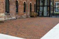 red brick floor with two building in the background from top of a roof and on the ground is a brick wall