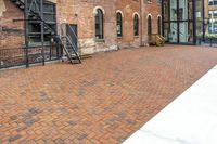 red brick floor with two building in the background from top of a roof and on the ground is a brick wall