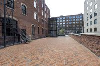 red brick floor with two building in the background from top of a roof and on the ground is a brick wall