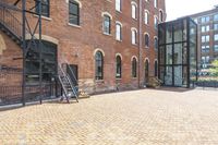 red brick floor with two building in the background from top of a roof and on the ground is a brick wall