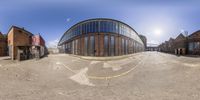 a fisheye view of an empty street and an office building and sidewalk by itself