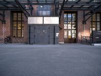 the entrance to the old warehouse with industrial iron doors and bicycles in the background in a city setting