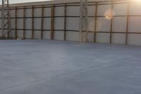 a person jumping a skate board in an empty building with a roof on it's side