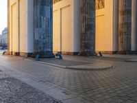 a person sits on top of a stone floor next to a street with pillars in the background