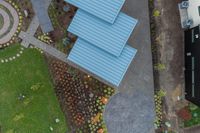 blue houses with trees and flowers outside are viewed from above, as seen from a drone