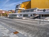 a box sitting in the middle of an empty concrete slab outside a building with a yellow facade