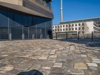 the large office building is located in the center of a cobblestone plaza of the city