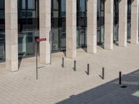 some red signs that are on the ground near a building with a building in the background