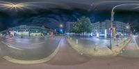 360 - angle image of street at night with traffic and buildings on it's sides