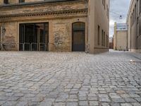 an old brick building with stairs and bicycle racks on one side of the street, outside