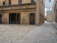 an old brick building with stairs and bicycle racks on one side of the street, outside