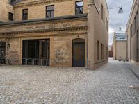 an old brick building with stairs and bicycle racks on one side of the street, outside