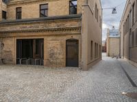 an old brick building with stairs and bicycle racks on one side of the street, outside