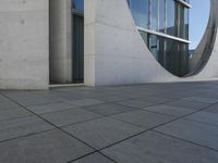 a gray wall that has been designed to have windows inside it and the building in the background is made from white marble tiles