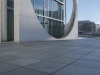 a gray wall that has been designed to have windows inside it and the building in the background is made from white marble tiles