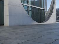 a gray wall that has been designed to have windows inside it and the building in the background is made from white marble tiles