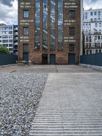 a building that is on some stones with other buildings in the background and one building has windows