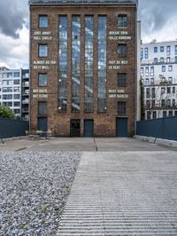 a building that is on some stones with other buildings in the background and one building has windows