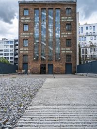 a building that is on some stones with other buildings in the background and one building has windows