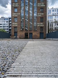 a building that is on some stones with other buildings in the background and one building has windows