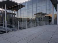 a glass and aluminum building with a staircase near a building entrance and a reflection in the glass
