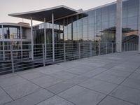a glass and aluminum building with a staircase near a building entrance and a reflection in the glass
