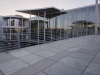 a glass and aluminum building with a staircase near a building entrance and a reflection in the glass