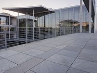 a glass and aluminum building with a staircase near a building entrance and a reflection in the glass