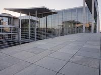 a glass and aluminum building with a staircase near a building entrance and a reflection in the glass